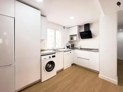 a kitchen with white cabinets and a washer and dryer at Apartamento La Caleta Grupo AC Gestion in Cádiz
