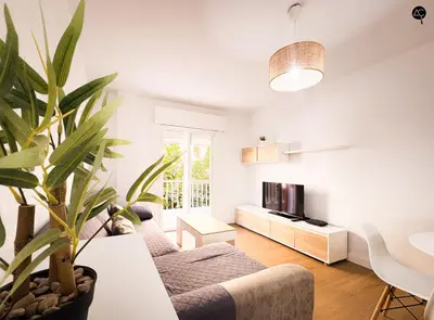 a living room with a couch and a potted plant at Apartamento La Caleta Grupo AC Gestion in Cádiz