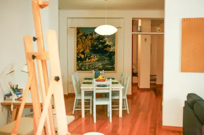 a dining room with a table with chairs and a painting at Caleta Club - Rooftop Villa, Cádiz in Cádiz