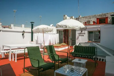 a balcony with chairs and a table and umbrella at Caleta Club - Rooftop Villa, Cádiz in Cádiz