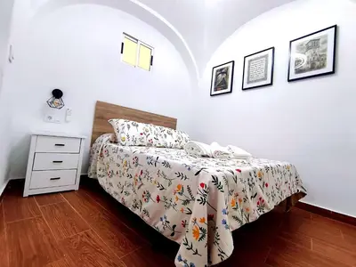 a bedroom with a bed and a dresser with a bedspread at Casita ENTREARCOS in Arcos de la Frontera