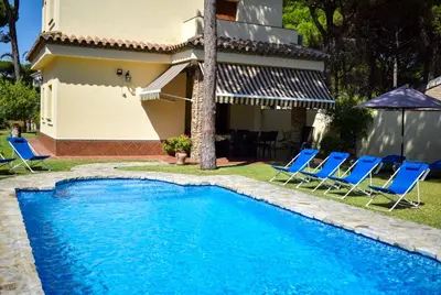 a swimming pool with chairs and a house at Villa La Torre in Novo Sancti Petri