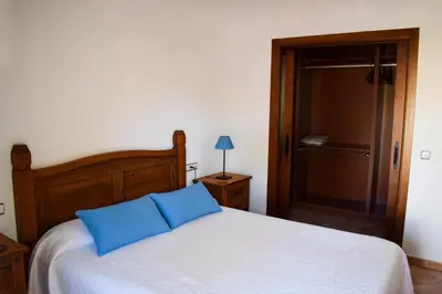 a bedroom with a bed with two blue pillows at Villa La Torre in Novo Sancti Petri