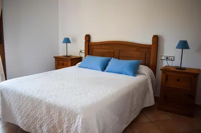 a bedroom with a large bed with blue pillows at Villa La Torre in Novo Sancti Petri