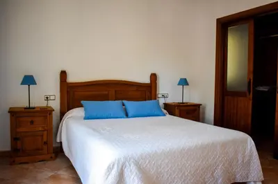 a bedroom with a bed with blue pillows on it at Villa La Torre in Novo Sancti Petri