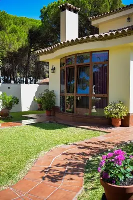 a house with a garden with flowers in the yard at Villa La Torre in Novo Sancti Petri