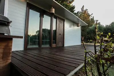 a house with a wooden deck with windows at Casita Verbena Retreat in Novo Sancti Petri