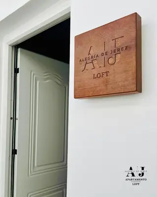 a wooden sign on a wall next to a door at Loft Alegría de Jerez in Jerez de la Frontera