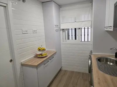 a kitchen with a sink and a bowl of bananas on a counter at GINVA - Costa Ballena & Jardines de Majadales in Chipiona