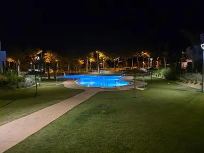 a night view of a swimming pool in a park at GINVA - Costa Ballena & Jardines de Majadales in Chipiona