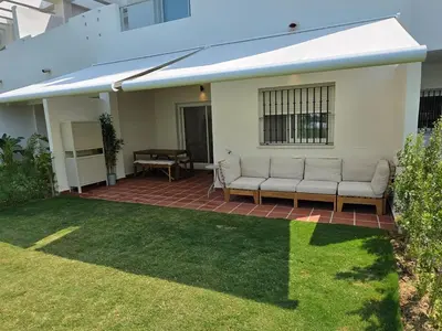 a house with two couches on a patio at GINVA - Costa Ballena & Jardines de Majadales in Chipiona