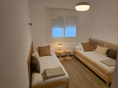 a living room with two beds and a window at GINVA - Costa Ballena & Jardines de Majadales in Chipiona