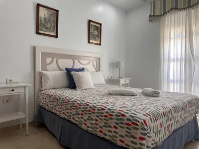 a bedroom with a bed with a colorful bedspread at La Torre de los Claustros - Ole Solutions in Jerez de la Frontera
