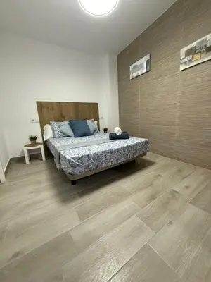 a bedroom with a bed and a wooden floor at Apartamento BF Jacuzzi Jerez in Jerez de la Frontera