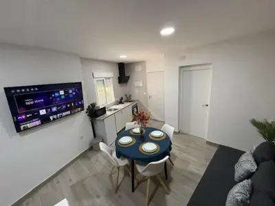 a living room with a blue table and a kitchen at Apartamento BF Jacuzzi Jerez in Jerez de la Frontera