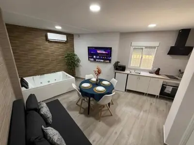 a kitchen and a living room with a table and a tub at Apartamento BF Jacuzzi Jerez in Jerez de la Frontera