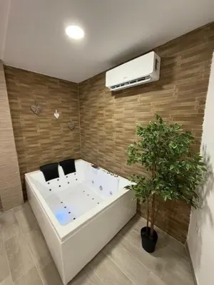 a room with a white tub and a plant at Apartamento BF Jacuzzi Jerez in Jerez de la Frontera