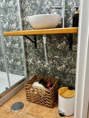 a bathroom with a sink on a shelf and a basket at Apartamento Molino de Algarrobo in Arcos de la Frontera