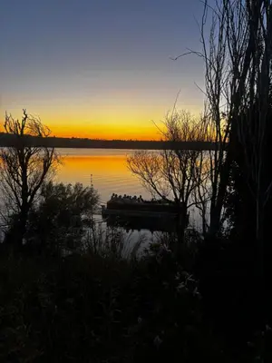 a sunset over a field with the sun setting over the water at Apartamento Molino de Algarrobo in Arcos de la Frontera