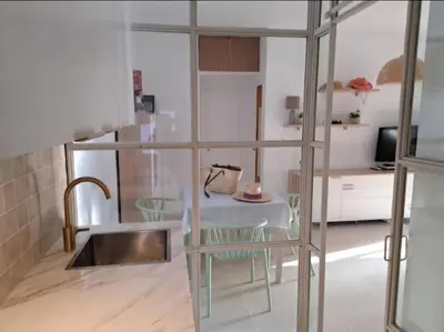 a kitchen with a sink and a table with chairs at Doña Violeta - La Barrosa in Novo Sancti Petri