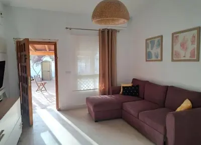 a living room with a purple couch in a room at Doña Violeta - La Barrosa in Novo Sancti Petri