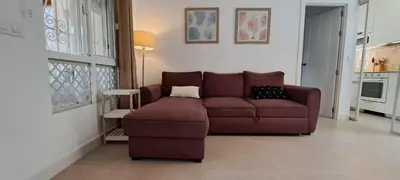 a living room with a brown couch and a table at Doña Violeta - La Barrosa in Novo Sancti Petri