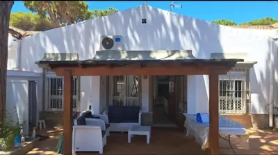 a large pergola in front of a white house at Doña Violeta - La Barrosa in Novo Sancti Petri
