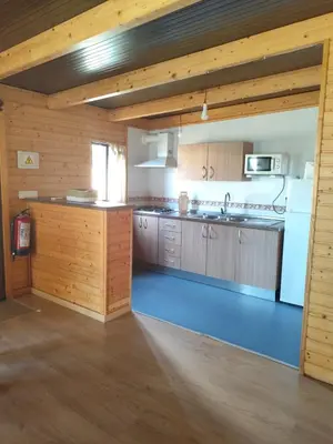 a large kitchen with wooden cabinets and a refrigerator at Brisa&Mar in Chiclana de la Frontera