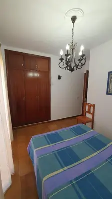 a bedroom with a bed and a chandelier at Costa Playasol in Novo Sancti Petri