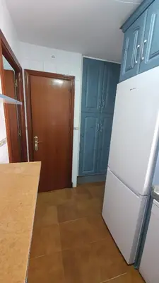 a kitchen with a white refrigerator and blue cabinets at Costa Playasol in Novo Sancti Petri