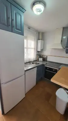 a kitchen with blue cabinets and a white refrigerator at Costa Playasol in Novo Sancti Petri