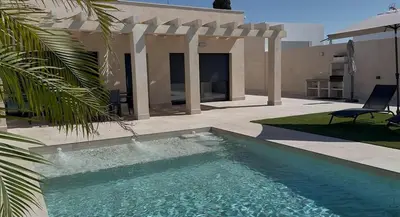 a swimming pool in front of a house at Casa Isabel in Chipiona