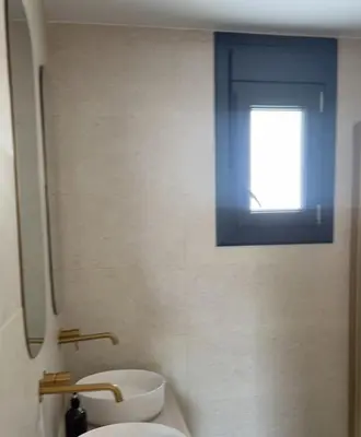 a bathroom with a window and a toilet and a sink at Casa Isabel in Chipiona