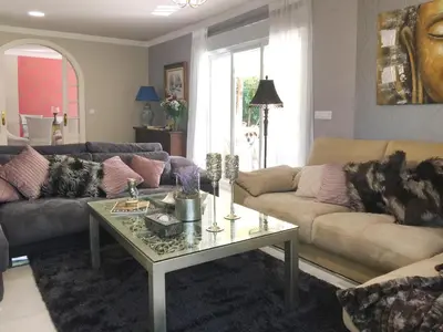 a living room with couches and a coffee table at Villa de Lujo con Jardines y Piscina in El Puerto de Santa María
