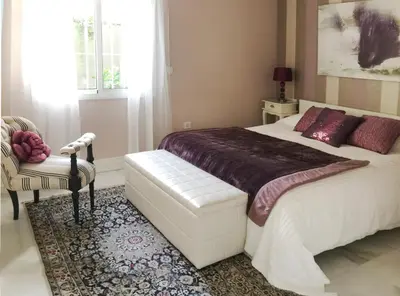a bedroom with a large white bed and a chair at Villa de Lujo con Jardines y Piscina in El Puerto de Santa María