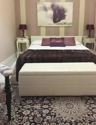 a bedroom with a large white bed with a bench at Villa de Lujo con Jardines y Piscina in El Puerto de Santa María
