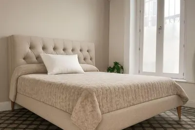 a bed in a room with a large bed with a pillow at Preciosa villa con patio céntrica in San Fernando