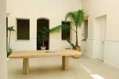a wooden table in a room with potted plants at Preciosa villa con patio céntrica in San Fernando