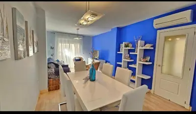 a dining room with a white table and blue walls at Atardeceres en Bajoguía in Sanlúcar de Barrameda
