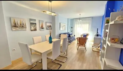 a dining room and living room with a table and chairs at Atardeceres en Bajoguía in Sanlúcar de Barrameda