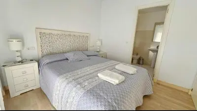 a bedroom with a bed with two towels on it at Atardeceres en Bajoguía in Sanlúcar de Barrameda