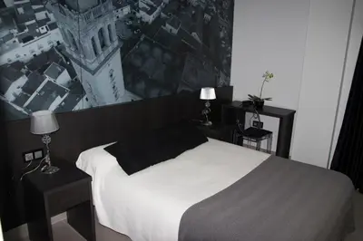 a bedroom with a white bed and two night stands at Hotel Barrio Nuevo in Lebrija
