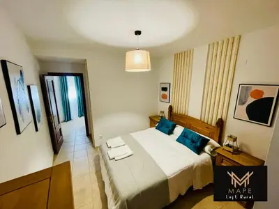 a bedroom with a large bed with blue pillows at Mape Loft Rural El MIMBRAL in Algar