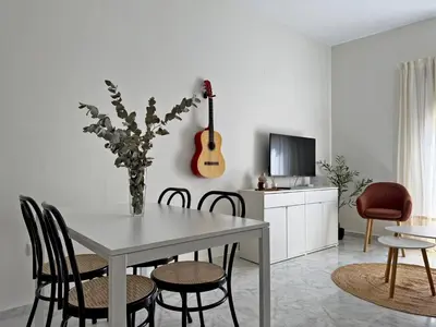 a dining room with a table and chairs and a guitar at El Compás de Jerez - Ole Solutions in Jerez de la Frontera
