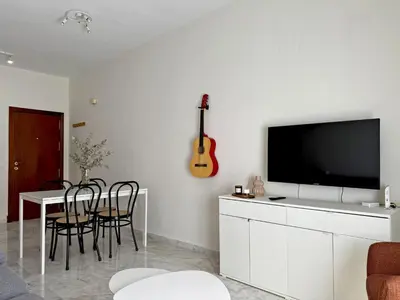 a living room with a television and a table with chairs at El Compás de Jerez - Ole Solutions in Jerez de la Frontera