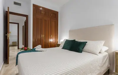 a bedroom with a large white bed with green pillows at Paseo Maritimo 3 Dormitorios in Cádiz