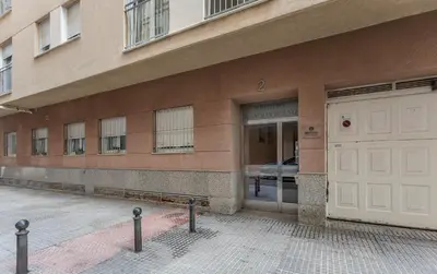 a building with a white door and a bench in front at Paseo Maritimo 3 Dormitorios in Cádiz