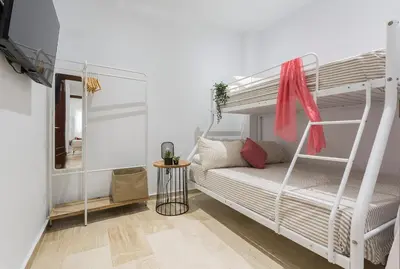 a bedroom with two bunk beds and a mirror at Paseo Maritimo 3 Dormitorios in Cádiz
