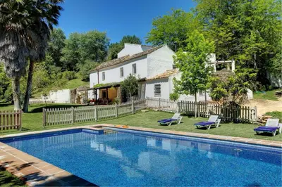 a large swimming pool in front of a house at El Molino del Pilón by Vintage Travel in Arcos de la Frontera