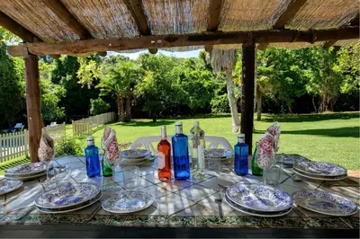 a table with plates and wine bottles on it at El Molino del Pilón by Vintage Travel in Arcos de la Frontera